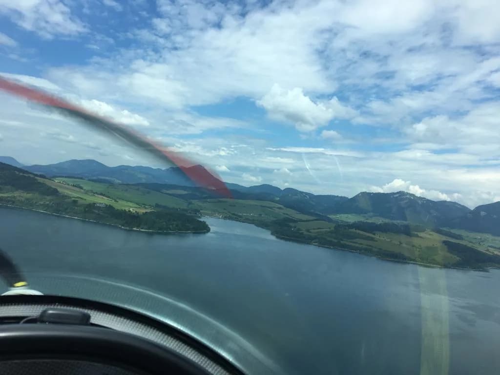 Horské jezero a okolní vrcholy z pohledu z kokpitu