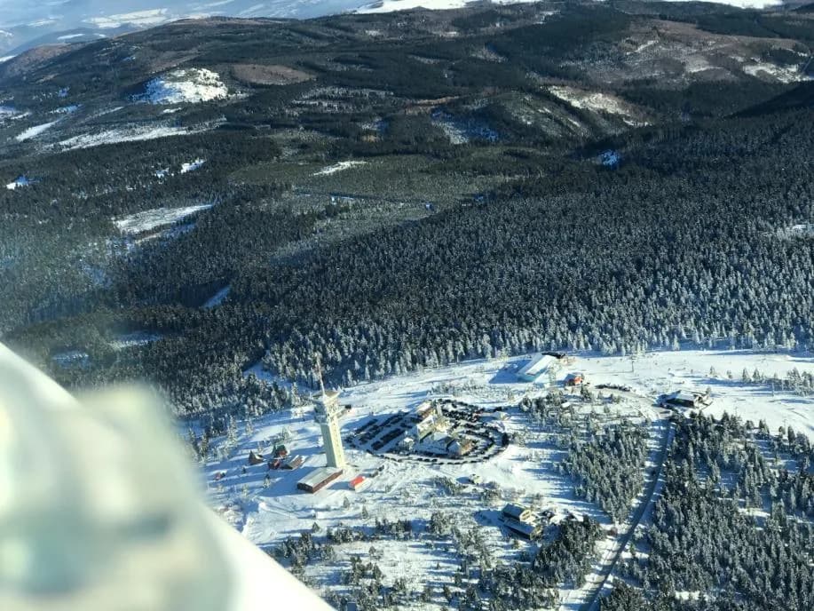 Zasněžený les a zástavba z ptačí perspektivy